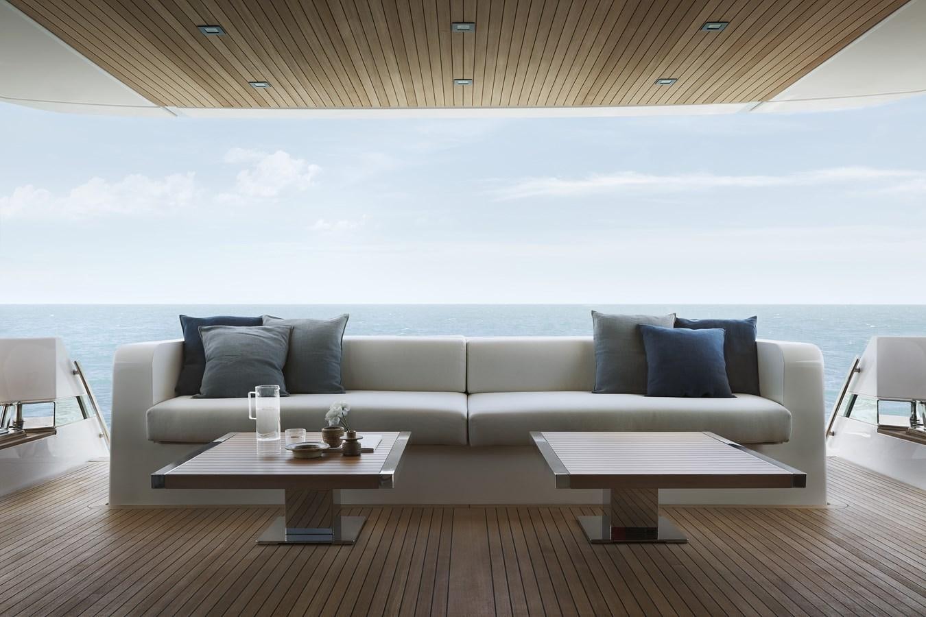a couch and a table in a room with a large body of water aboard STRADODO Yacht for Sale