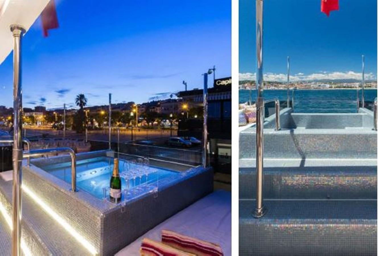 a pool with a bottle of wine on a balcony aboard GALA Yacht for Sale