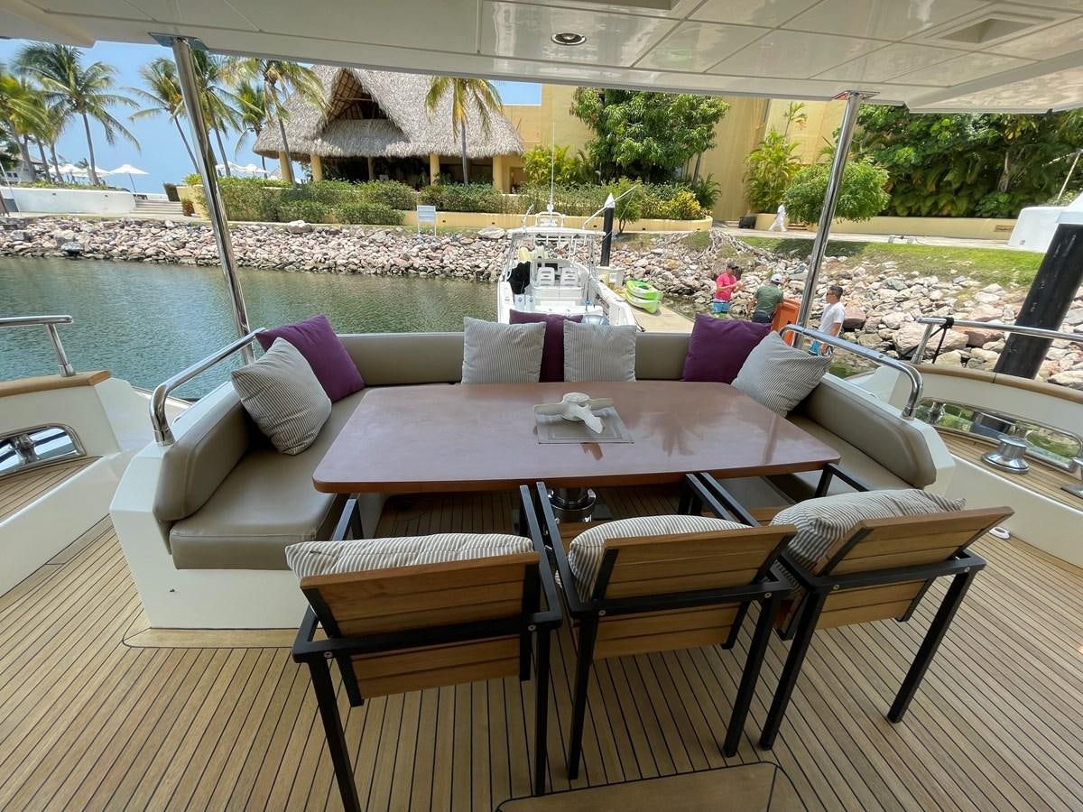 a table and chairs on a deck aboard 2008 AZIMUT 75 FLY @ IXTAPA ZIHUATANEJO Yacht for Sale
