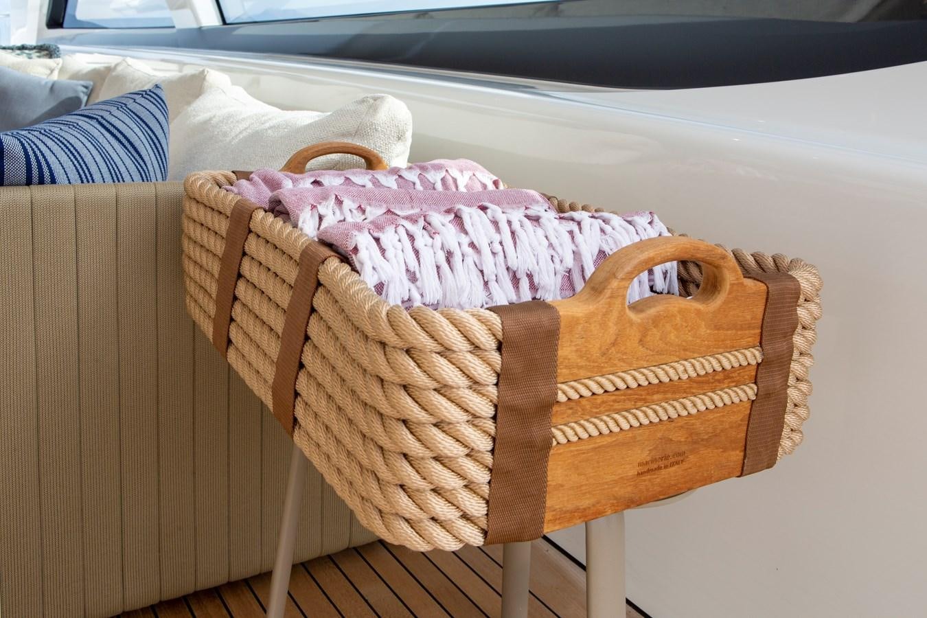a white and pink blanket on a wooden chair aboard MINE GAMES Yacht for Sale
