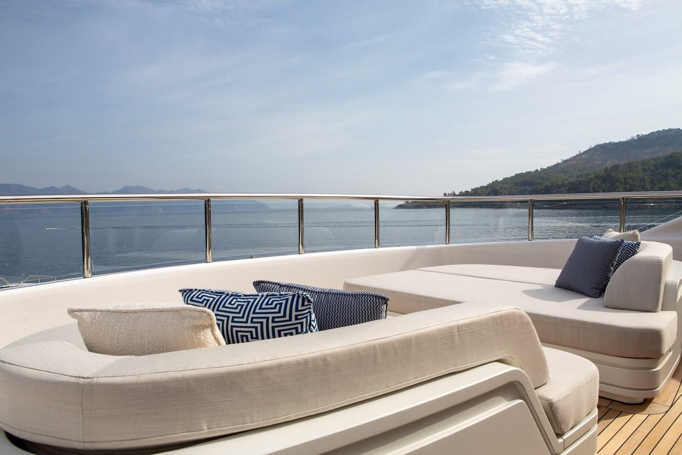 a bed on a deck overlooking a body of water aboard MINE GAMES Yacht for Sale