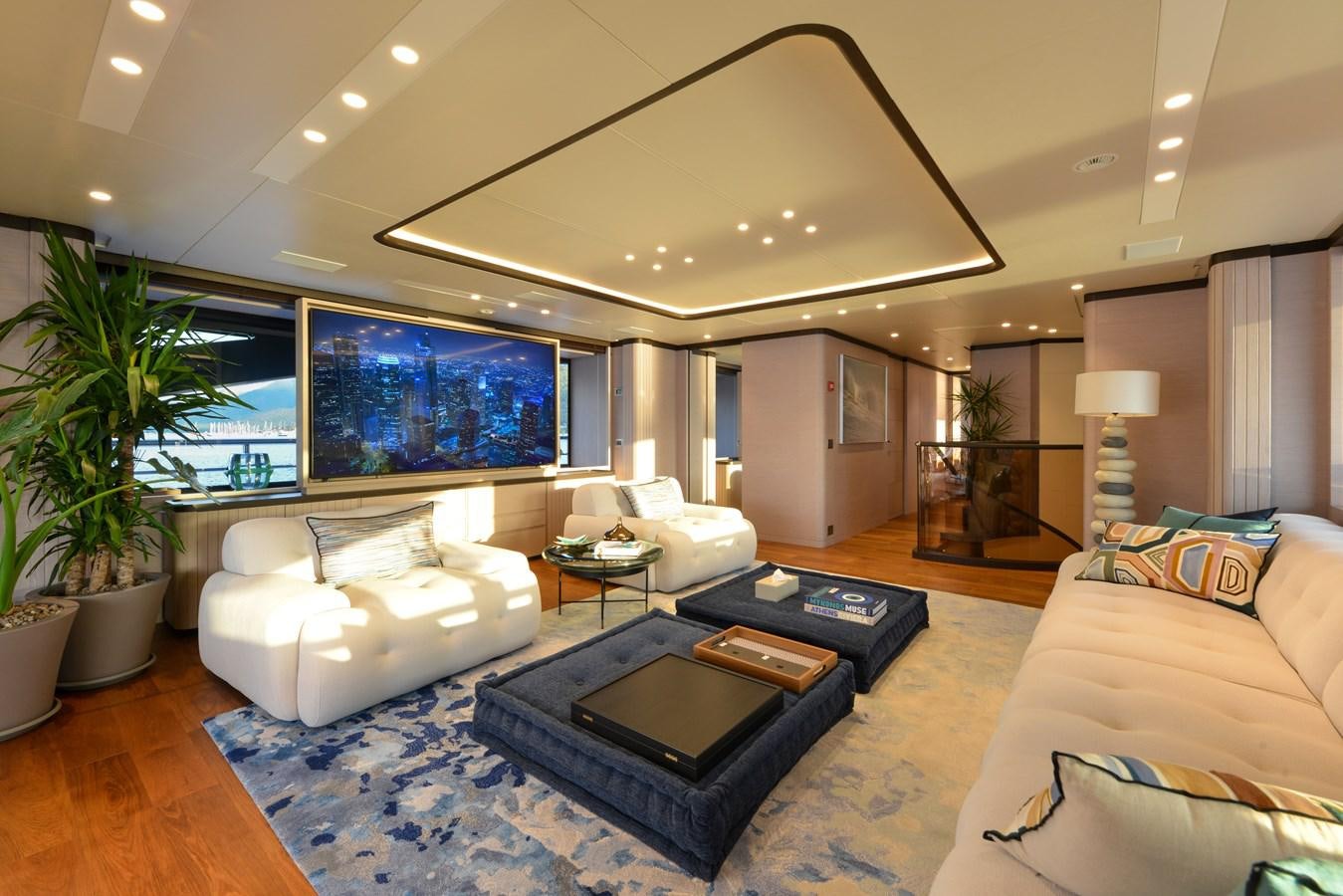 a living room with a large blue rug and a large screen aboard MINE GAMES Yacht for Sale