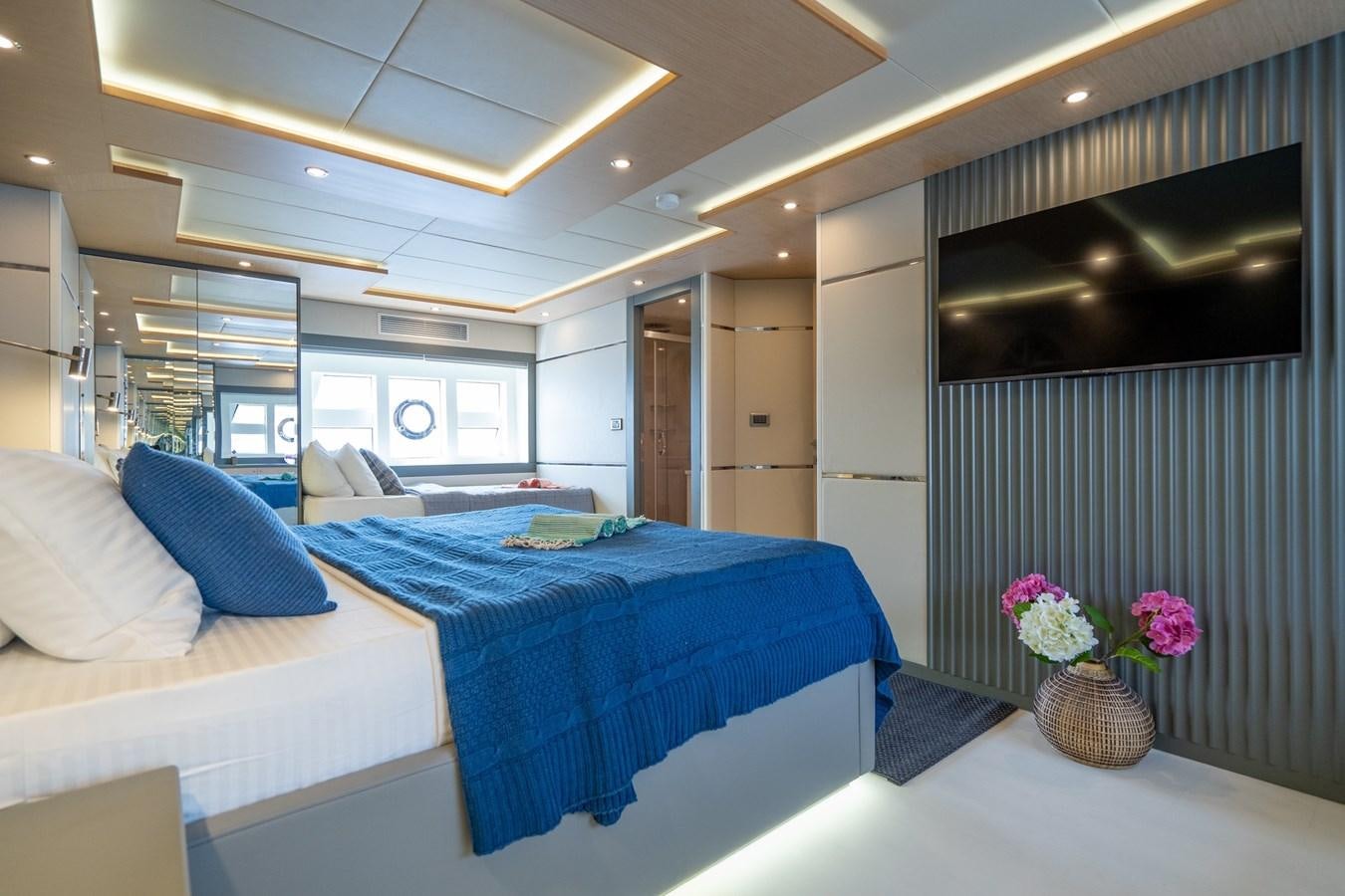 a bedroom with a bed and a desk aboard LAVIN Yacht for Sale