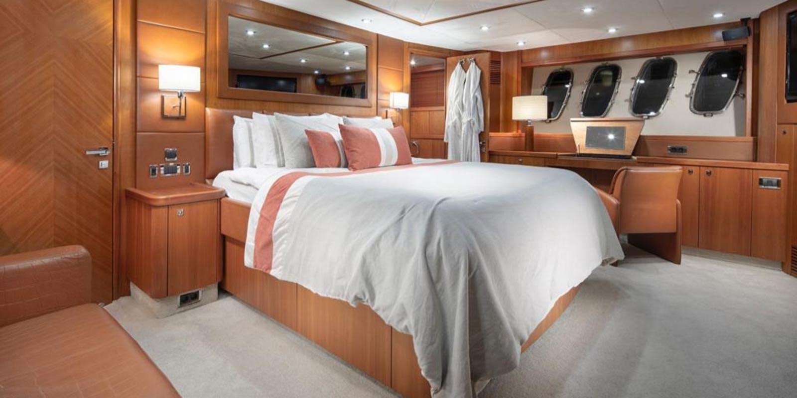 a room with a bed and desk aboard SWORDFISH 68 Yacht for Sale