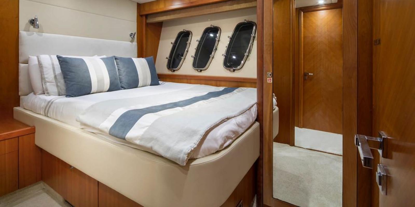 a bed with a white sheet and pillows on it aboard SWORDFISH 68 Yacht for Sale