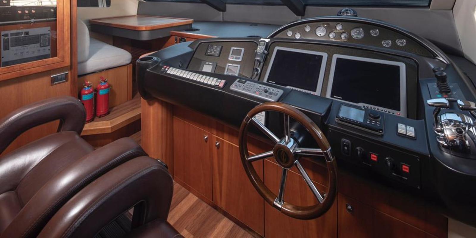 a black console with a black console and a wooden table and chairs aboard SWORDFISH 68 Yacht for Sale