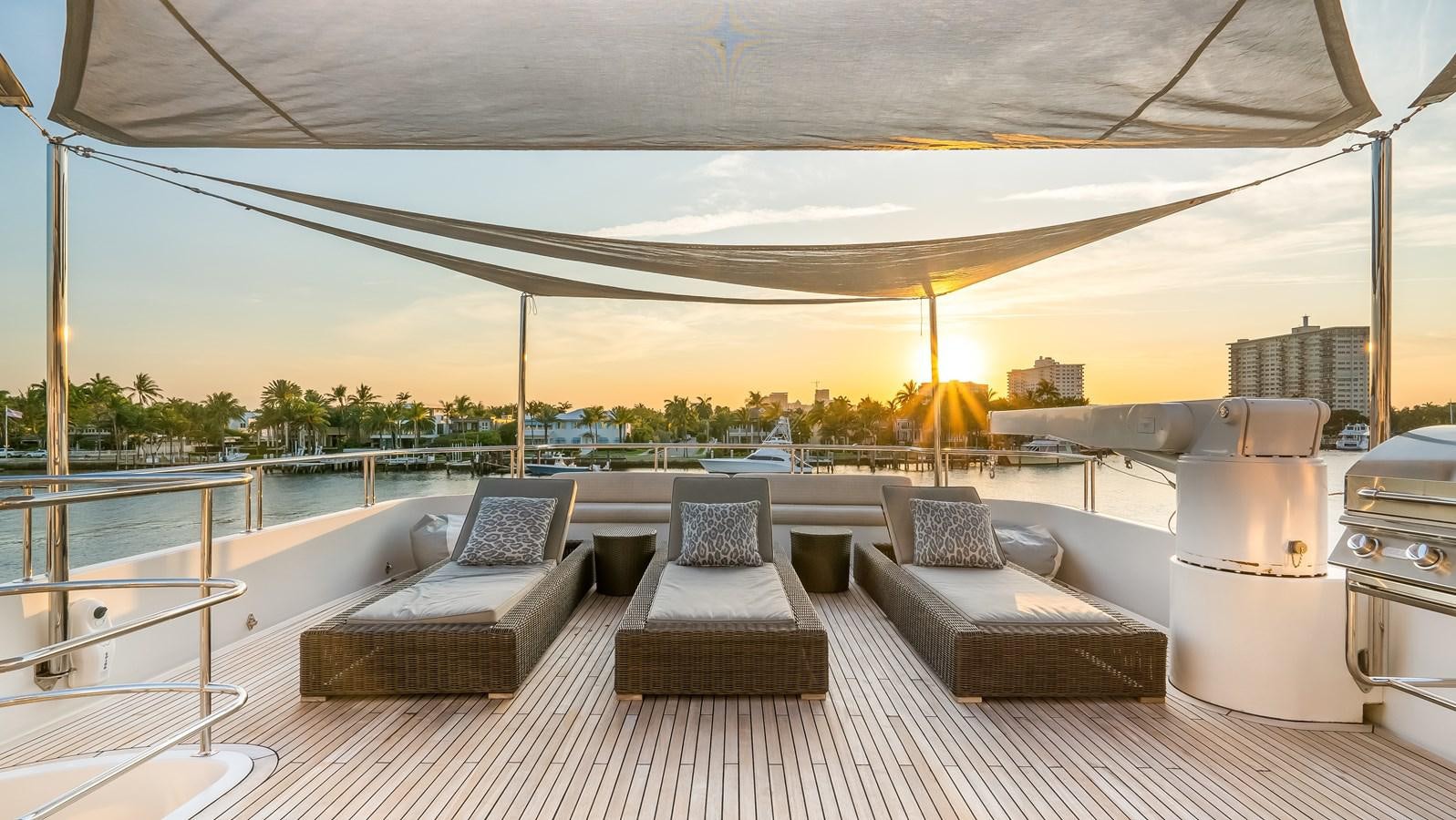 a large lounge area with a large patio area with a large pool and a city in the background aboard MISS STEPHANIE Yacht for Sale
