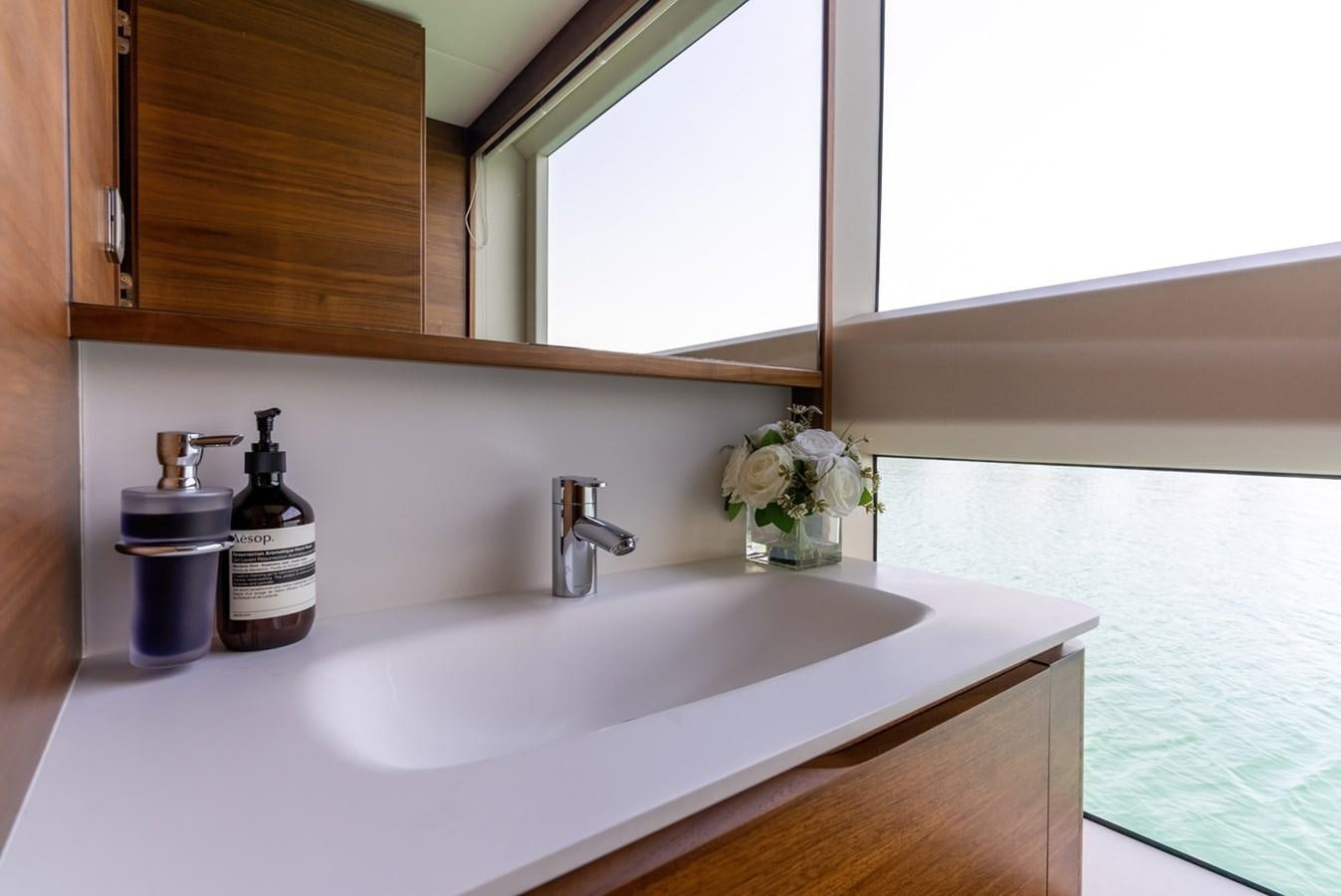 a bathroom sink with a mirror above it aboard 2022 PRINCESS X95 Yacht for Sale