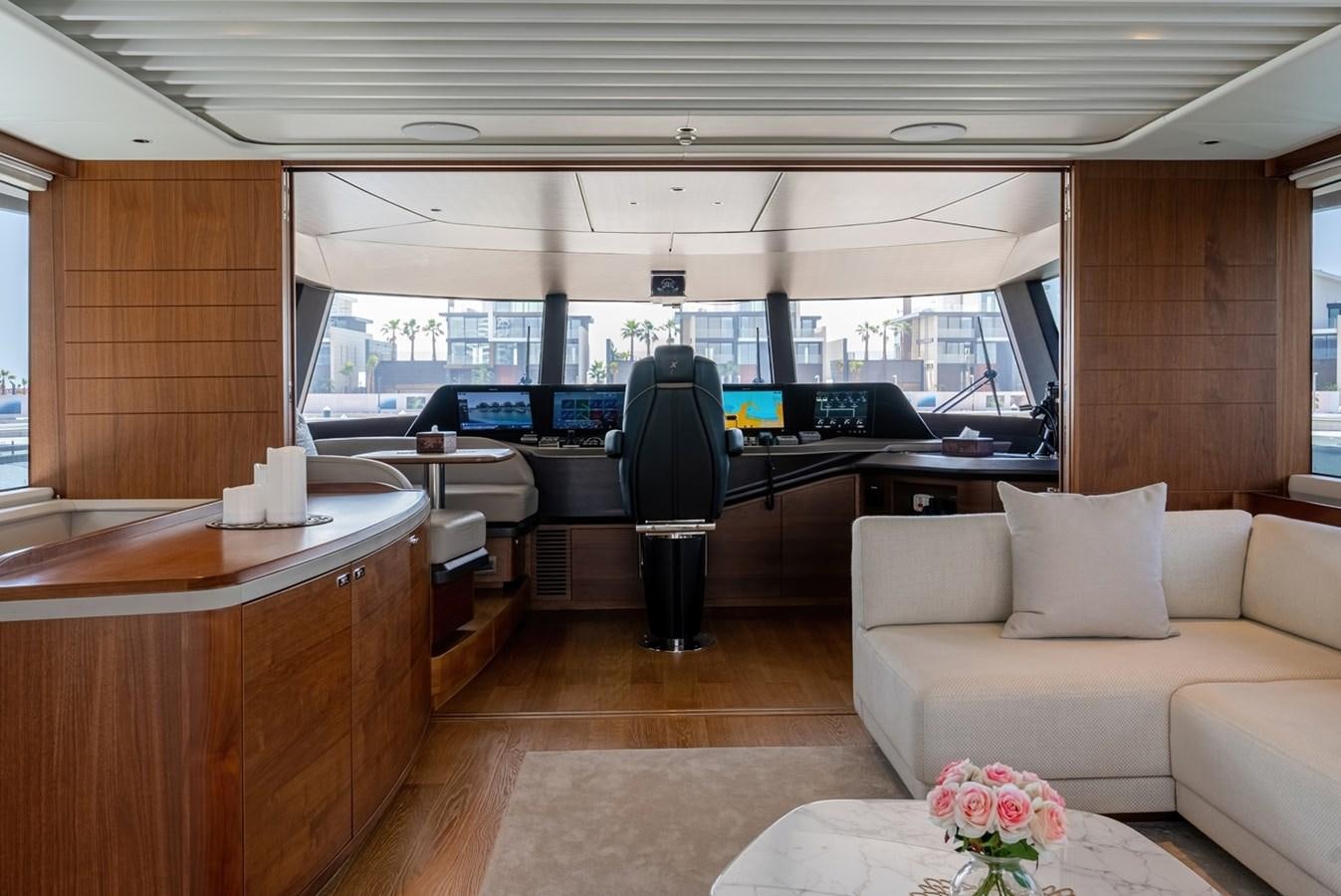 a room with a couch and a table with a laptop on it aboard 2022 PRINCESS X95 Yacht for Sale