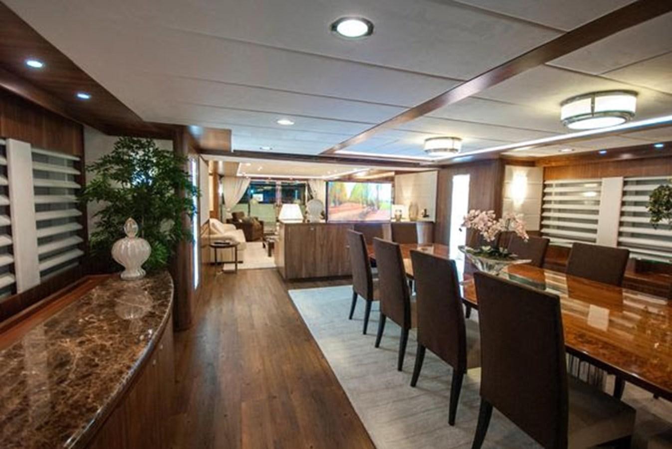 a large room with a wood floor and a table with chairs and a plant in it aboard 2024 MCP MY 140 Yacht for Sale
