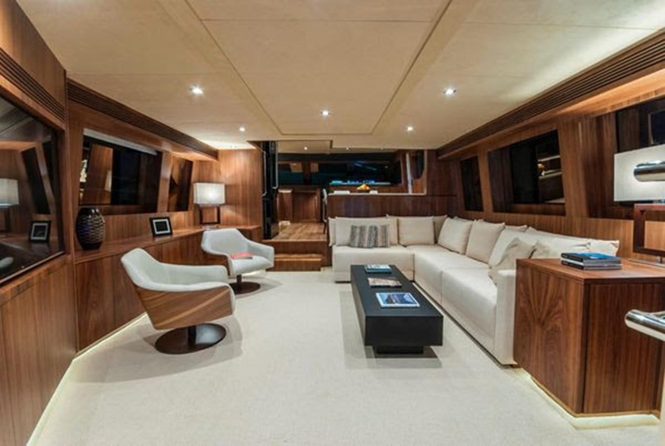 a living room with a large white couch and a large wood coffee table aboard 2024 MCP 76 MY Yacht for Sale