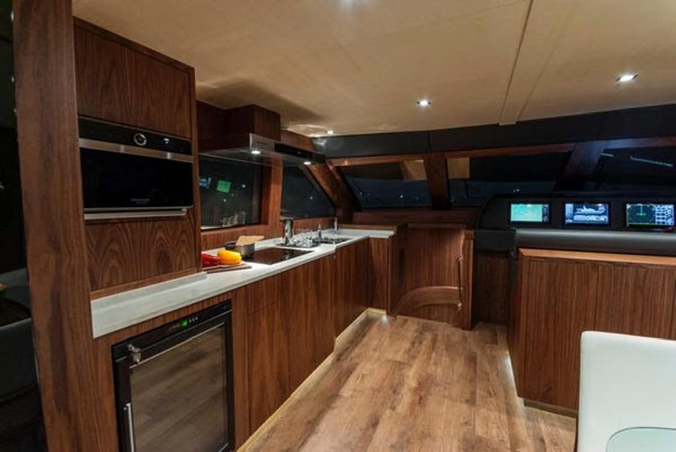 a kitchen with wooden cabinets aboard 2024 MCP 76 MY Yacht for Sale
