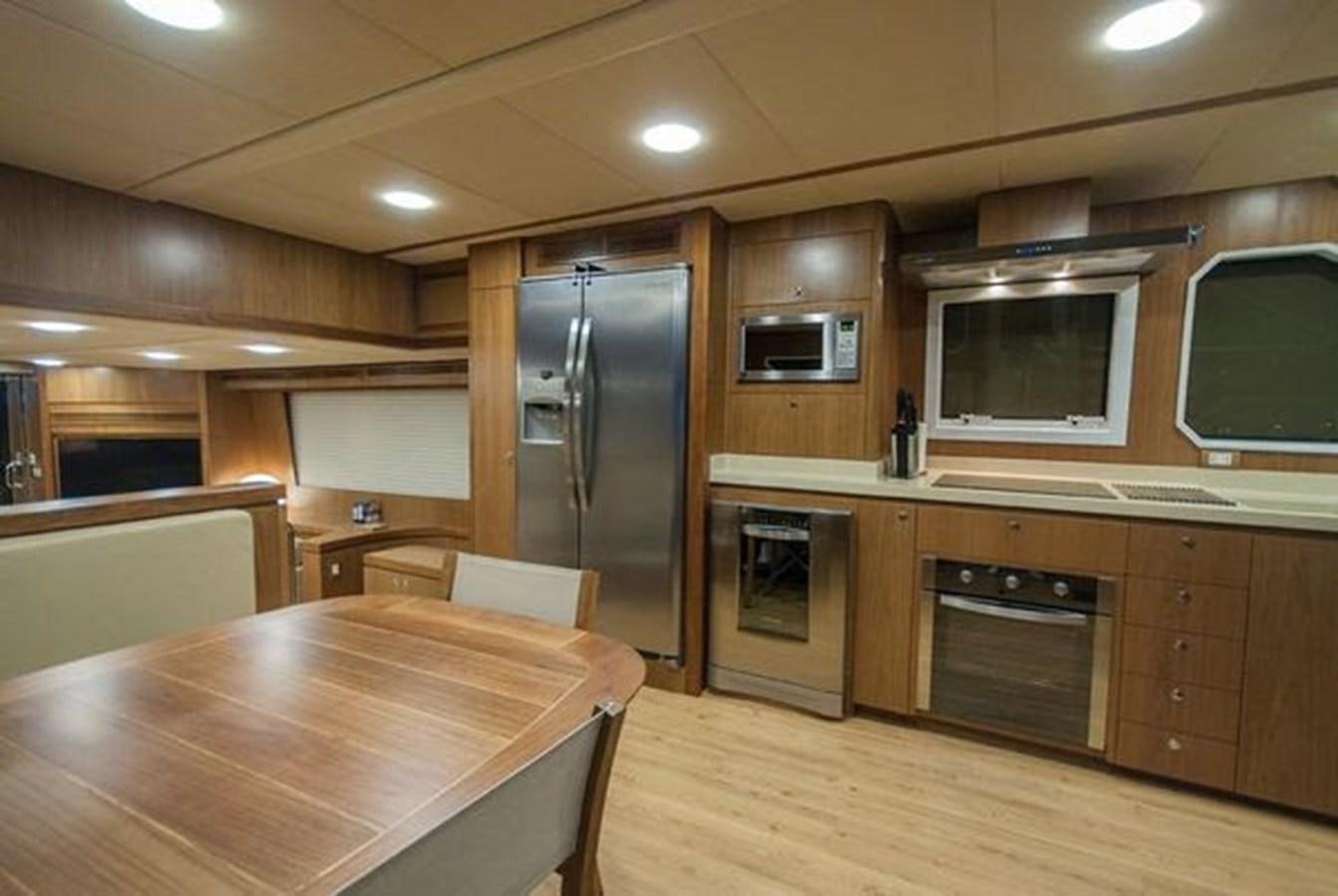 a kitchen with wooden cabinets aboard 2024 MCP 76 MY Yacht for Sale