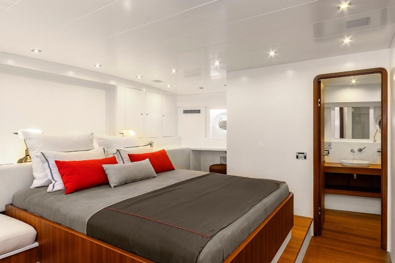 a bed with a red pillow aboard UBI BENE Yacht for Sale