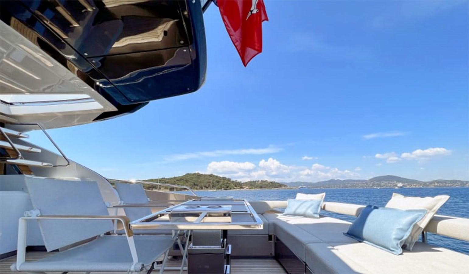 a deck with chairs and a flag on it aboard KAR Yacht for Sale