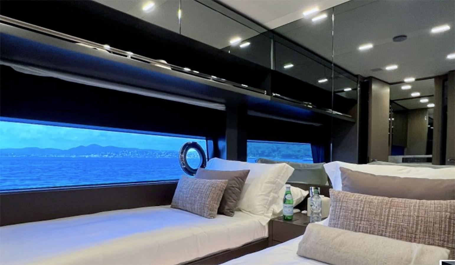 a room with a bed and a large window aboard KAR Yacht for Sale