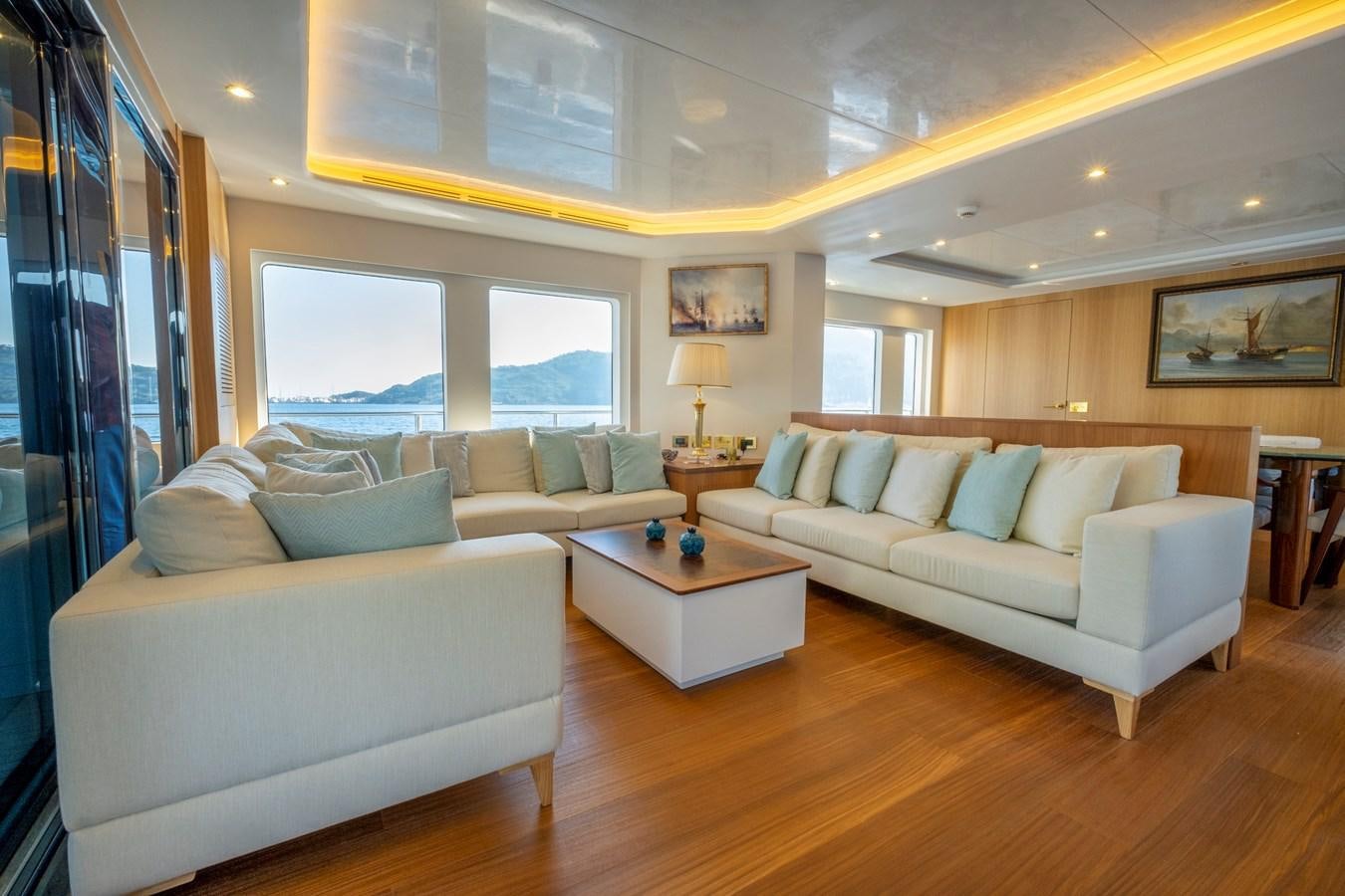 a living room with a couch and a window aboard MURAL 85 Yacht for Sale