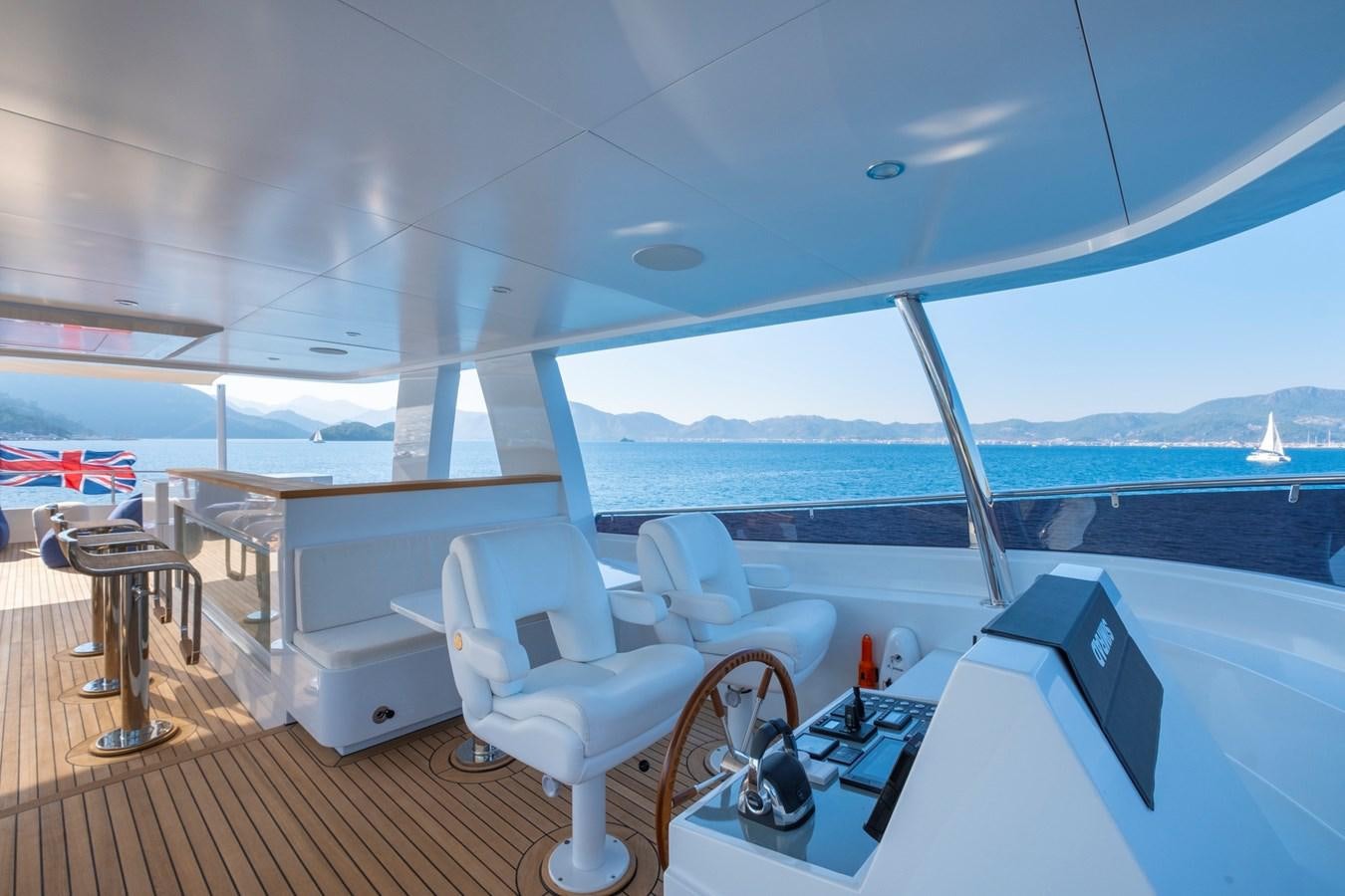 a room with a view of the water and boats in the background aboard MURAL 85 Yacht for Sale