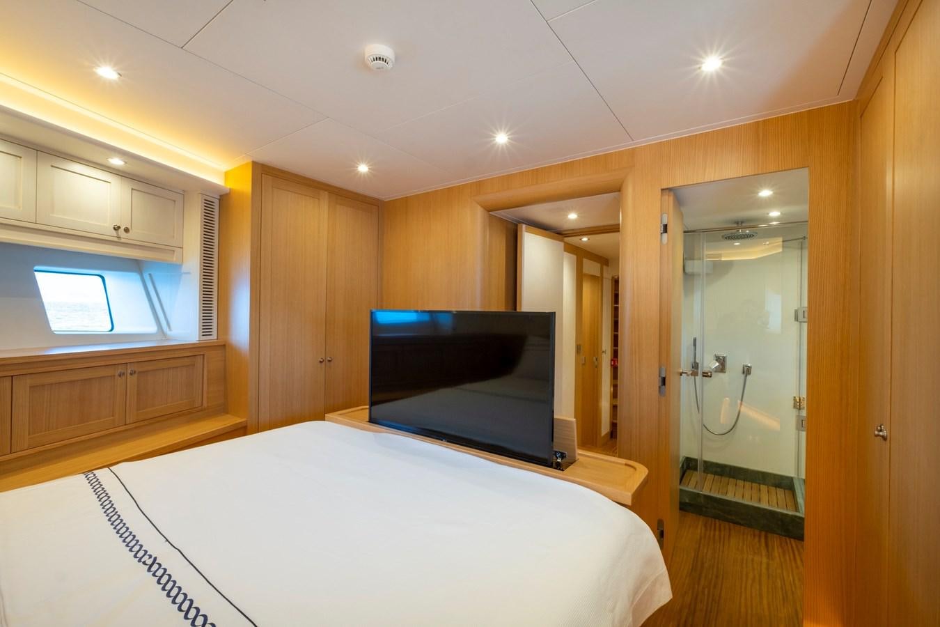a room with a bed and a television aboard MURAL 85 Yacht for Sale