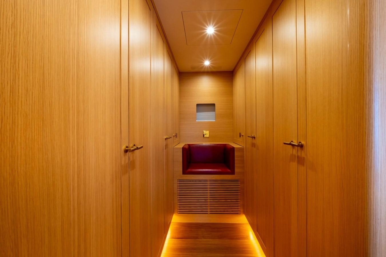 a room with a red couch and wood doors aboard MURAL 85 Yacht for Sale