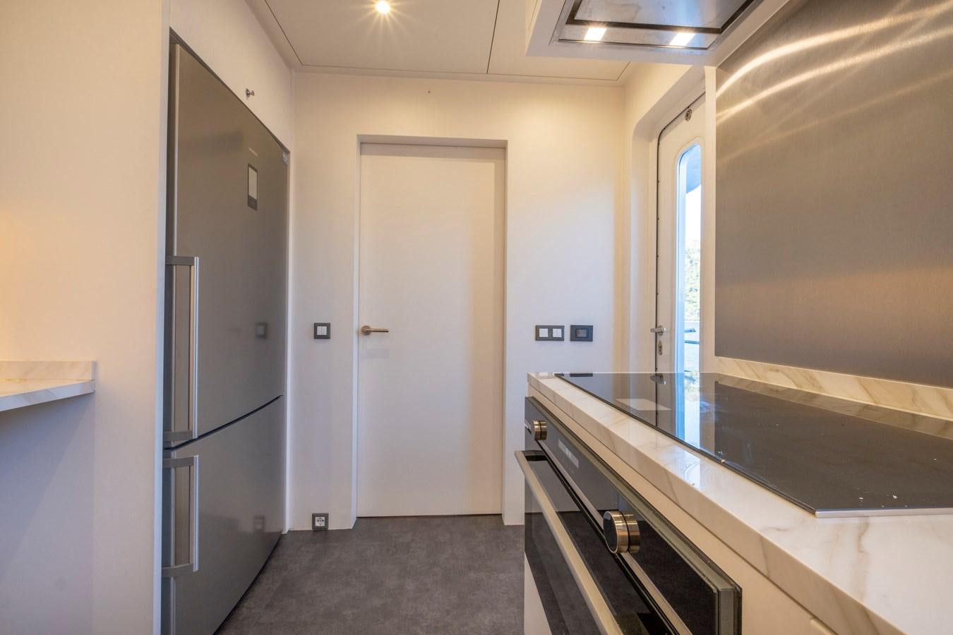 a kitchen with a large refrigerator aboard MURAL 85 Yacht for Sale