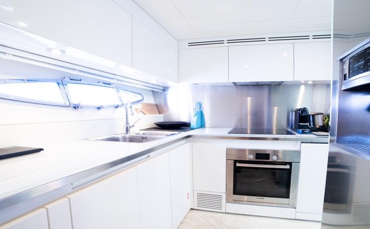a kitchen with white cabinets aboard BLUE MAMBA Yacht for Sale