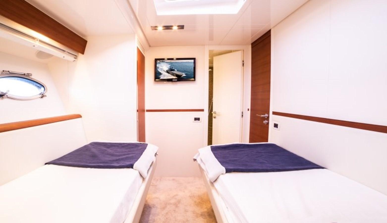 a room with beds and a television aboard BLUE MAMBA Yacht for Sale
