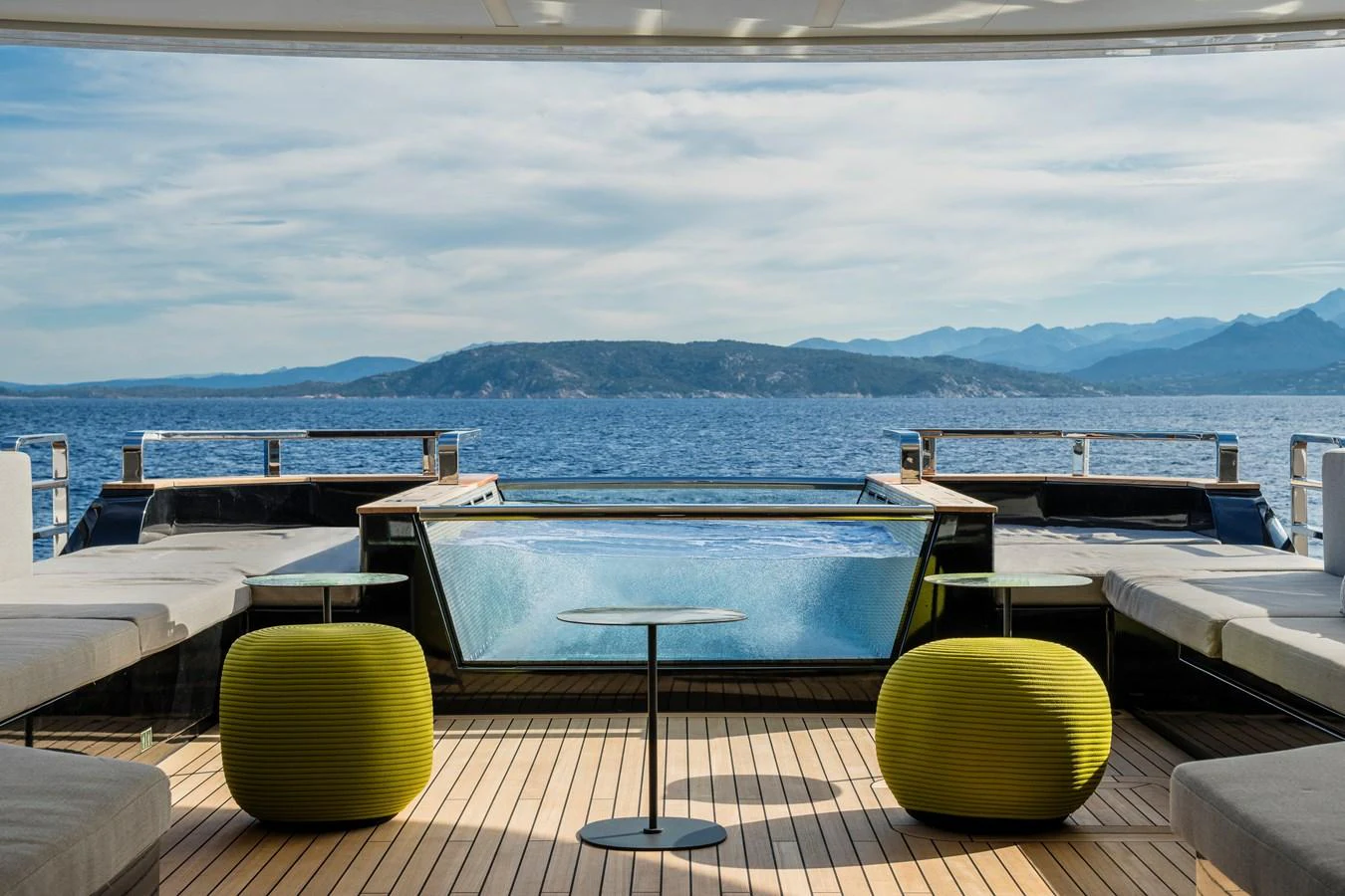 a deck with a view of the ocean and mountains in the background aboard ISA GT 45 Yacht for Sale