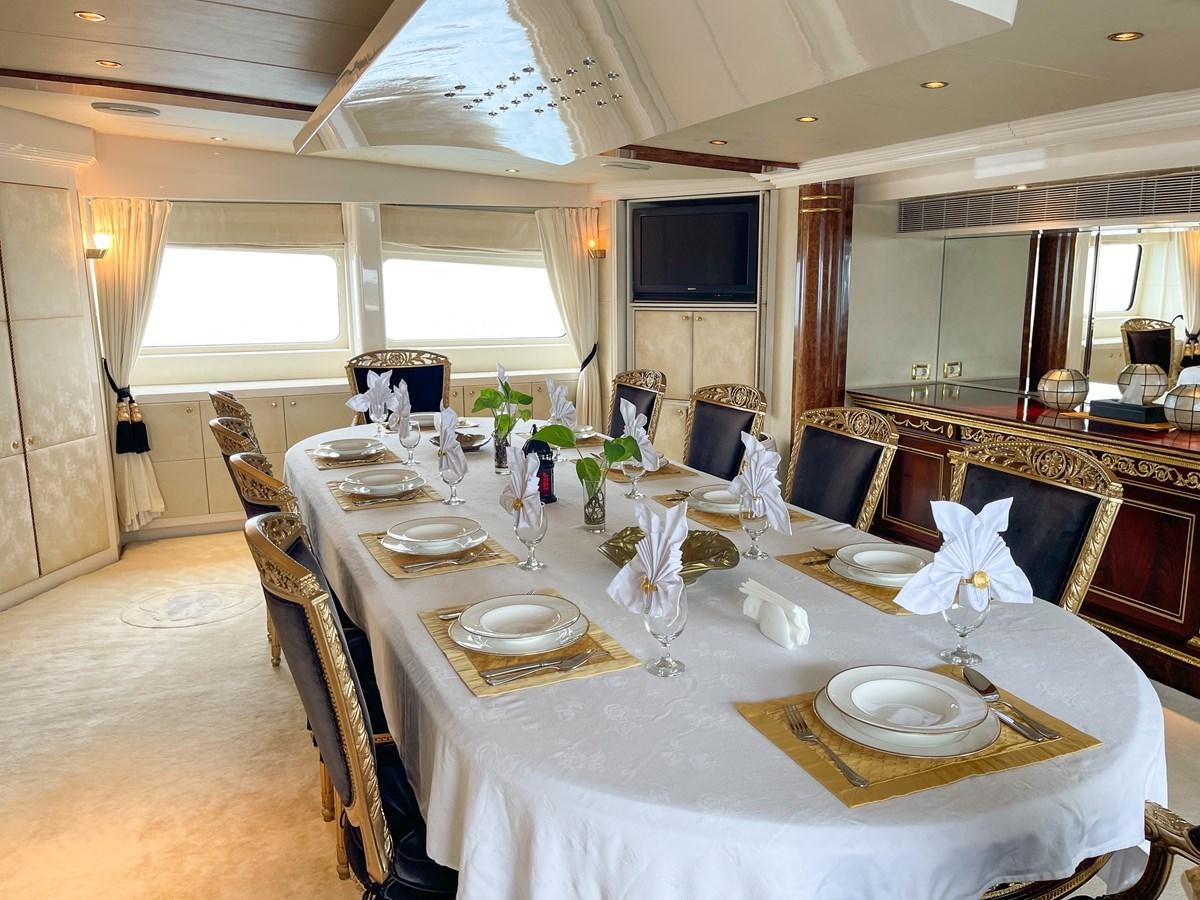 a dining room with a table set aboard OBSESSIONS Yacht for Sale