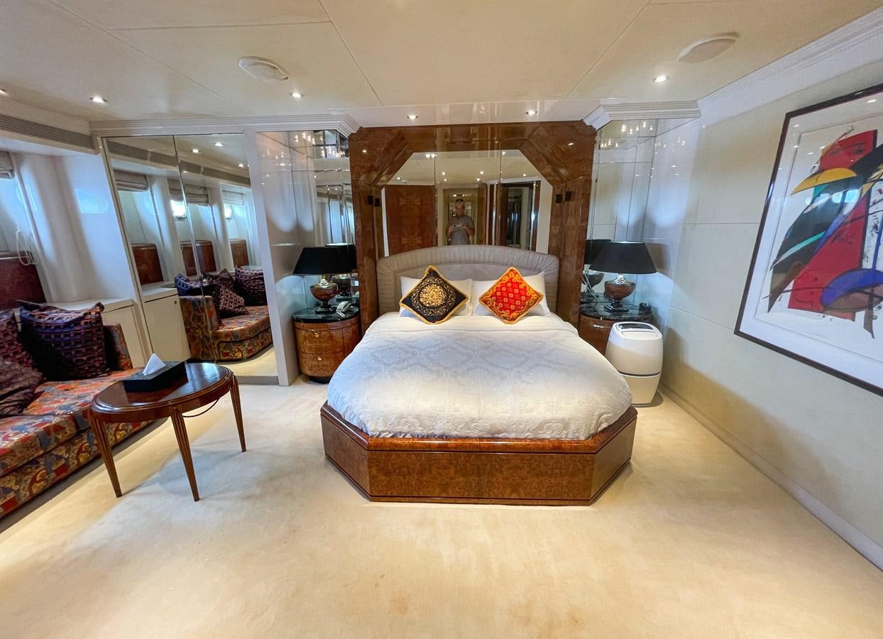 a large bedroom with a large mirror aboard OBSESSIONS Yacht for Sale