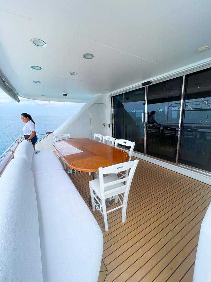 a person sitting at a table on a boat aboard OBSESSIONS Yacht for Sale