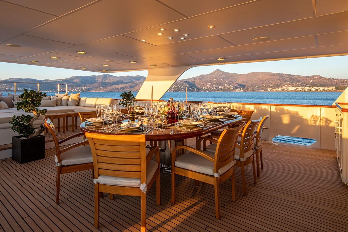 a table and chairs on a deck overlooking a body of water aboard ILLUSION I Yacht for Sale