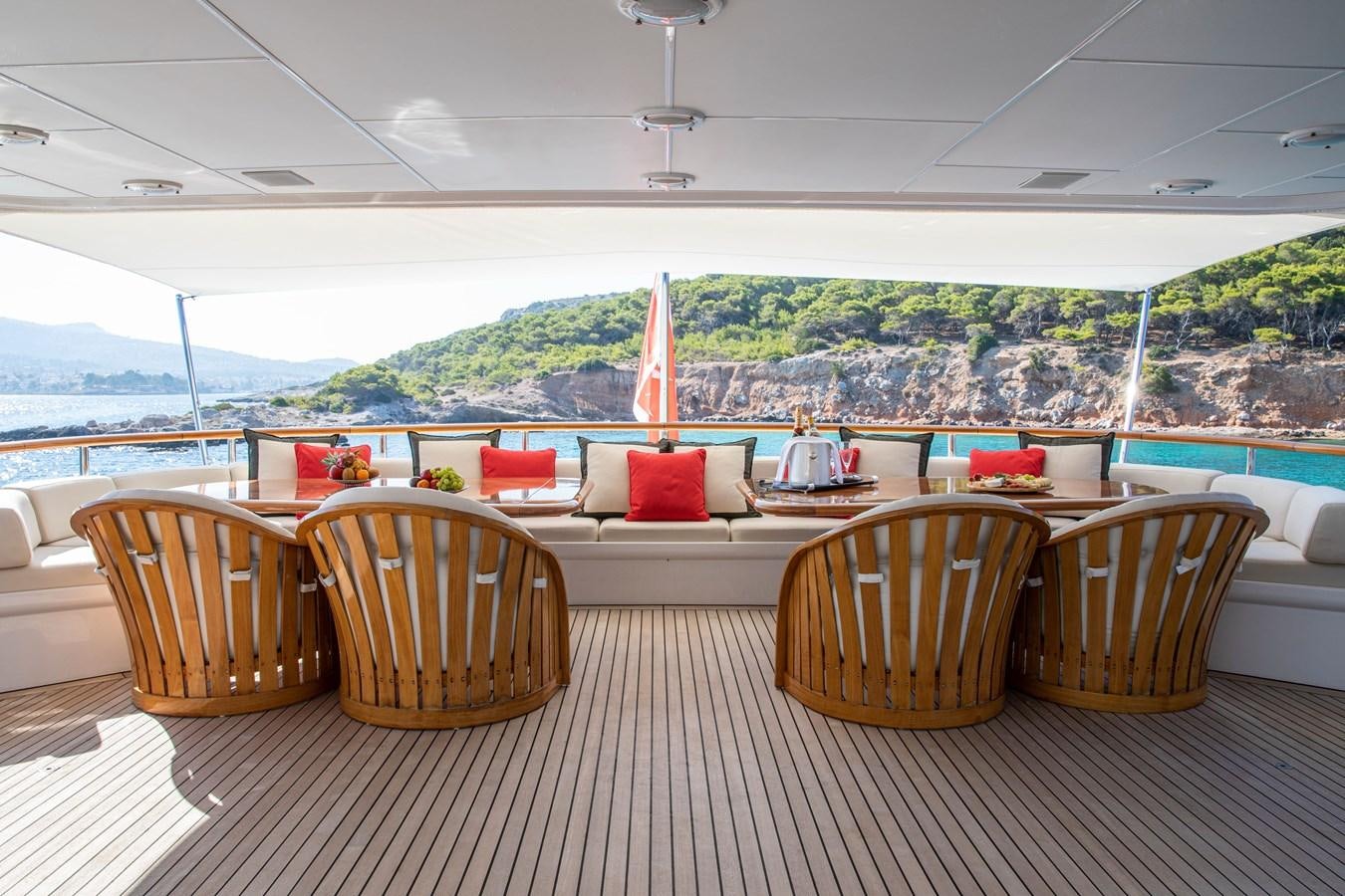 a deck with chairs and tables aboard ILLUSION I Yacht for Sale