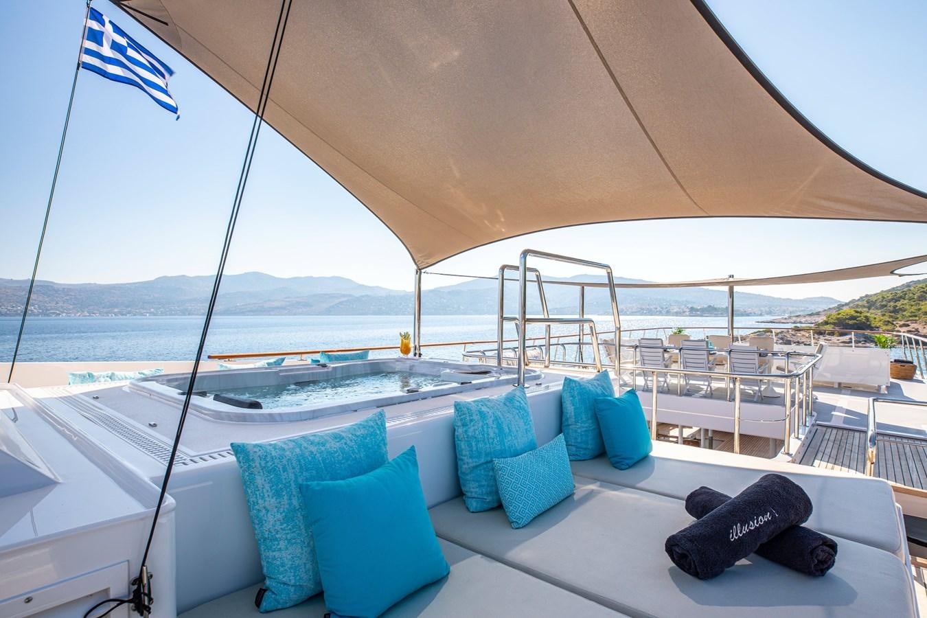 a large white lounge chair on a deck overlooking a large body of water aboard ILLUSION I Yacht for Sale