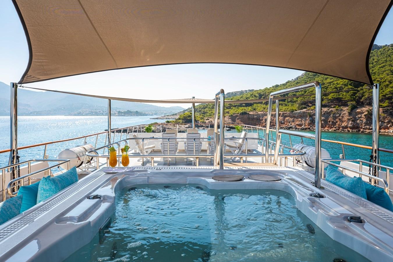 a pool with a large umbrella aboard ILLUSION I Yacht for Sale