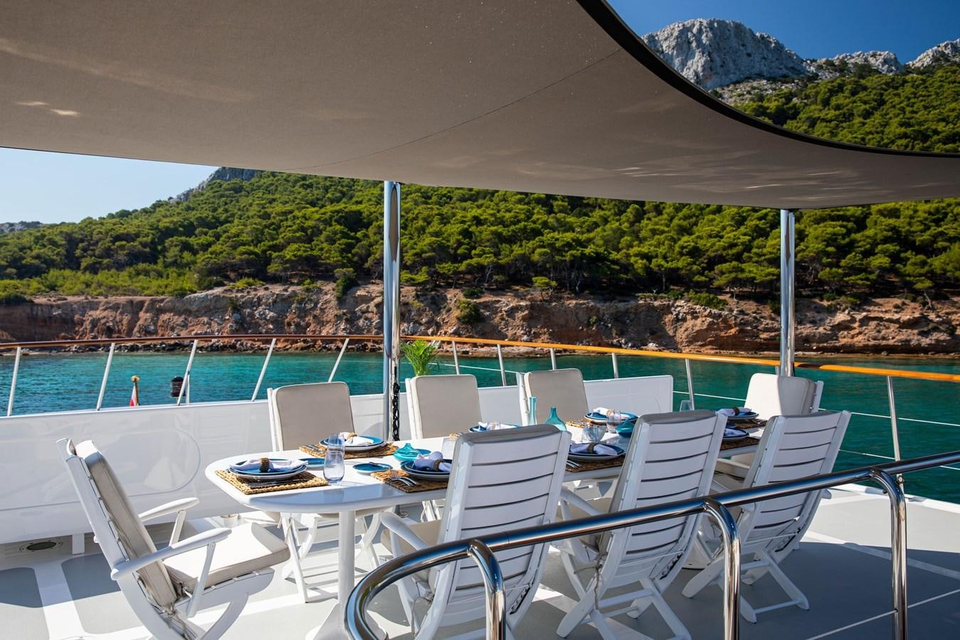 a table and chairs on a patio aboard ILLUSION I Yacht for Sale