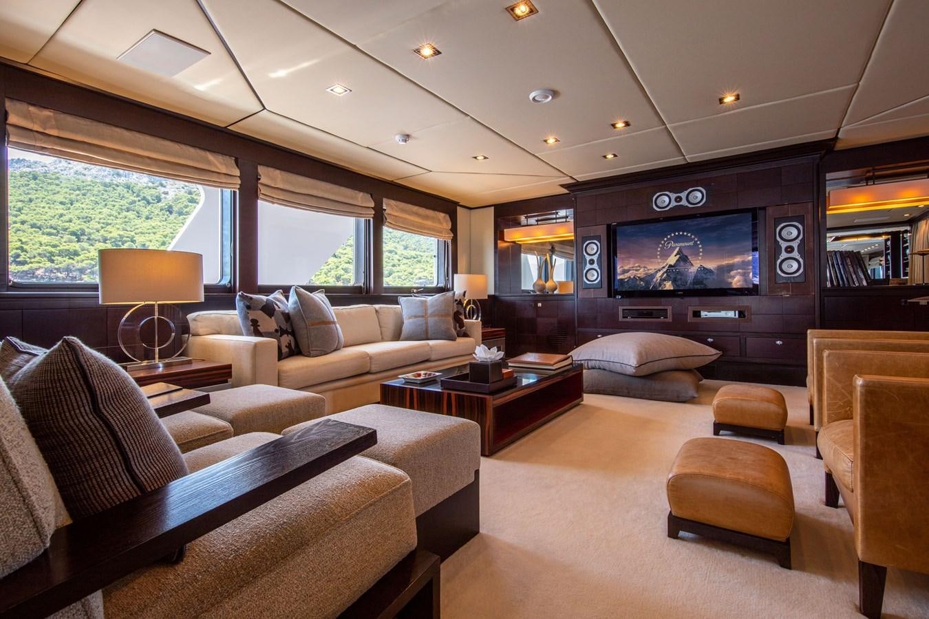 a living room with a tv and couches aboard ILLUSION I Yacht for Sale