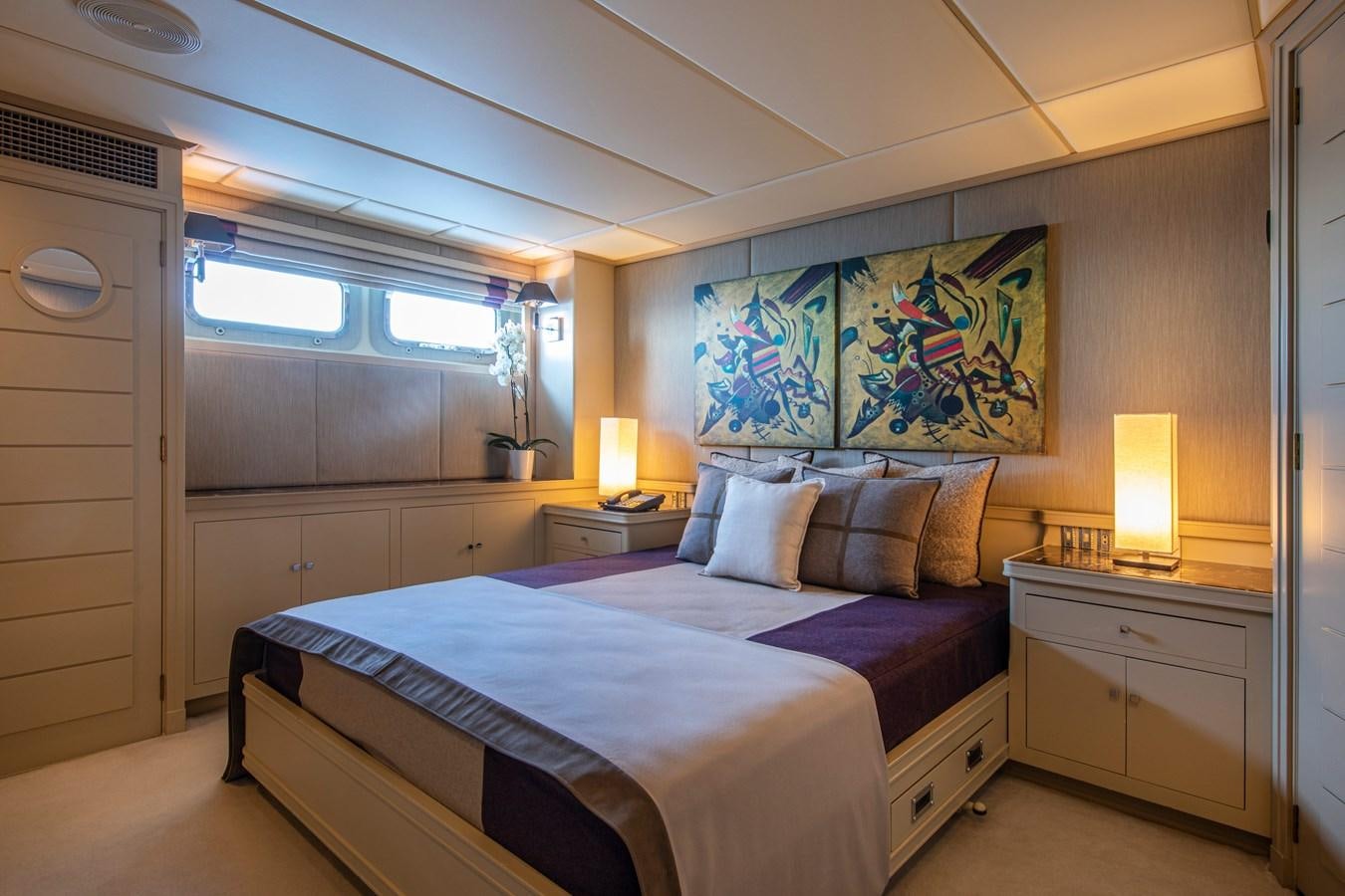 a bedroom with a bed and a desk aboard ILLUSION I Yacht for Sale