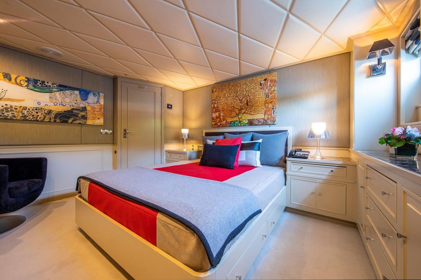 a bedroom with a bed and a fireplace aboard ILLUSION I Yacht for Sale