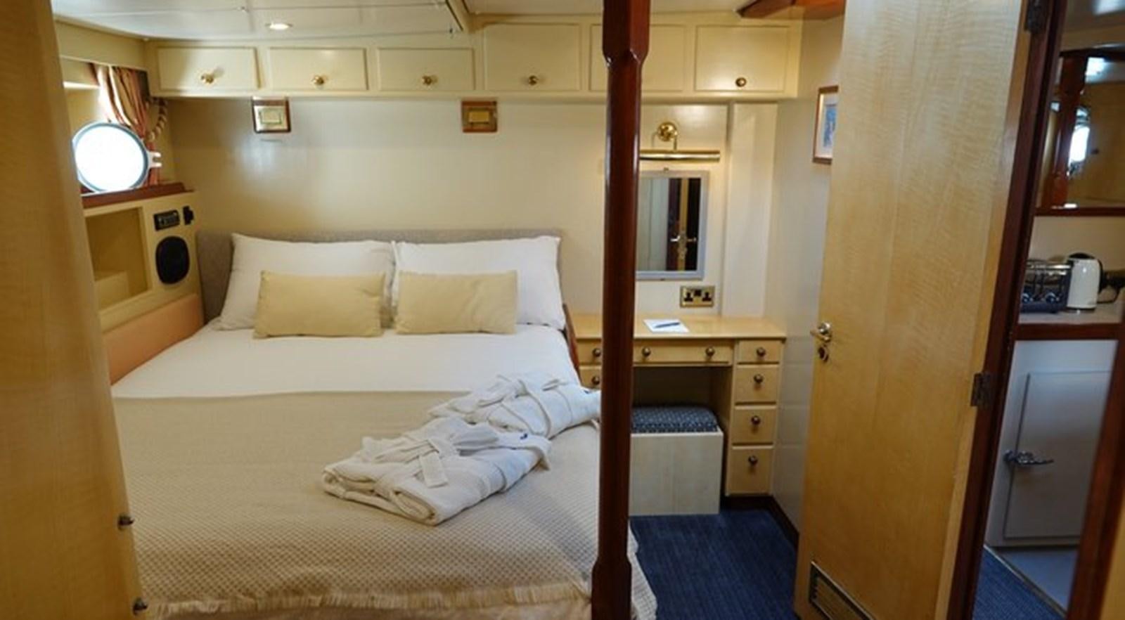 a room with a bed and a desk aboard WINDWEAVER OF PENNINGTON Yacht for Sale