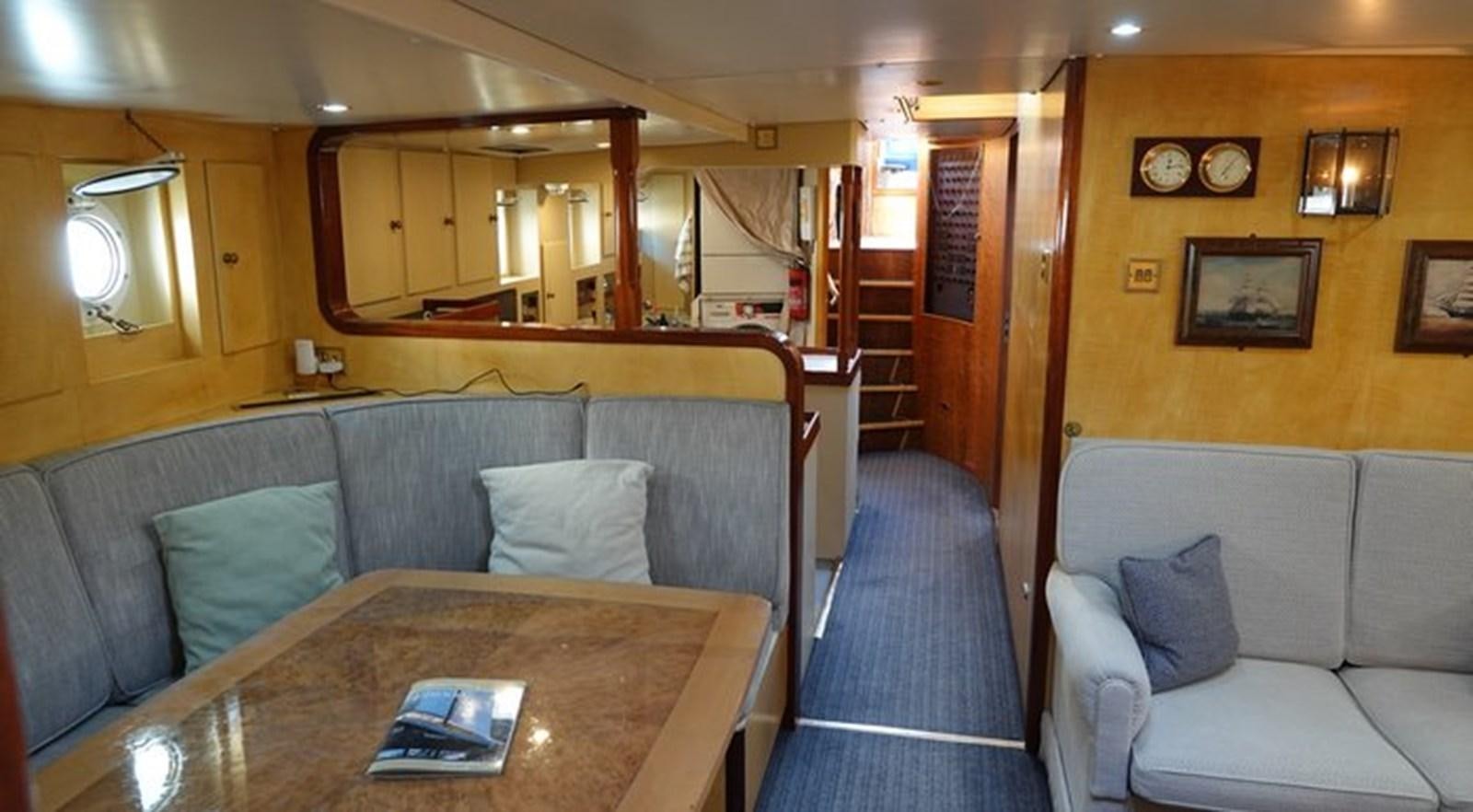 a living room with a couch and a table aboard WINDWEAVER OF PENNINGTON Yacht for Sale