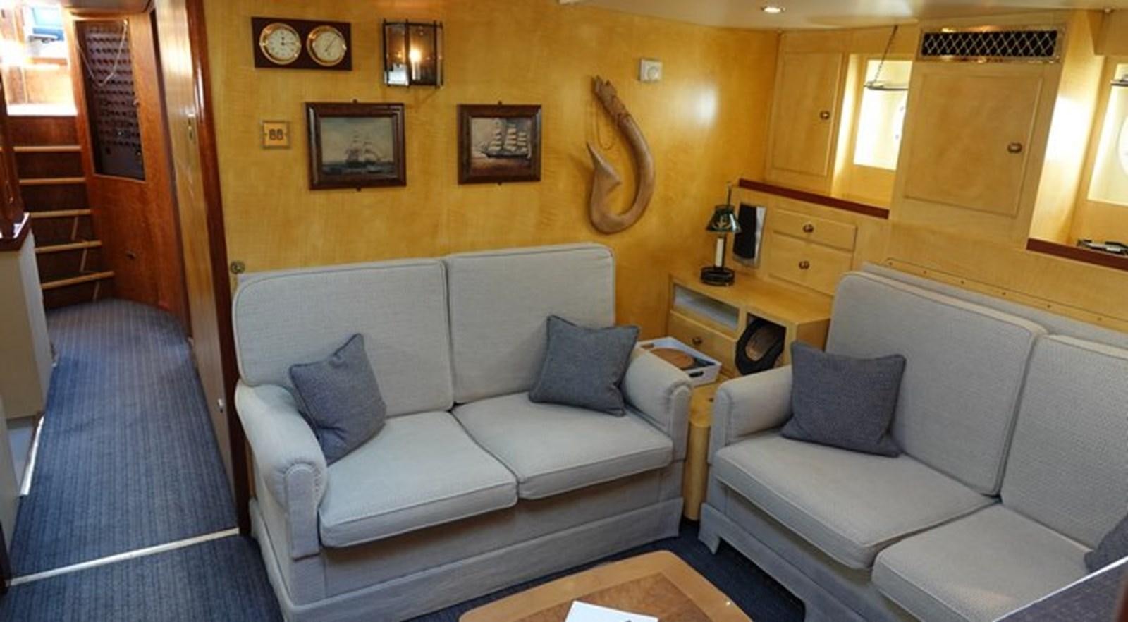 a living room with a couch and a table aboard WINDWEAVER OF PENNINGTON Yacht for Sale