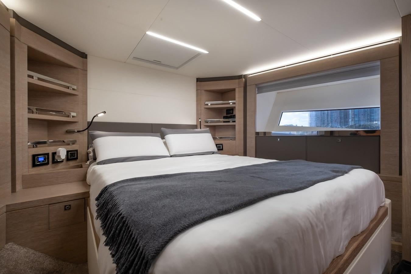 a bedroom with a bed and a bookcase aboard SHEVA Yacht for Sale