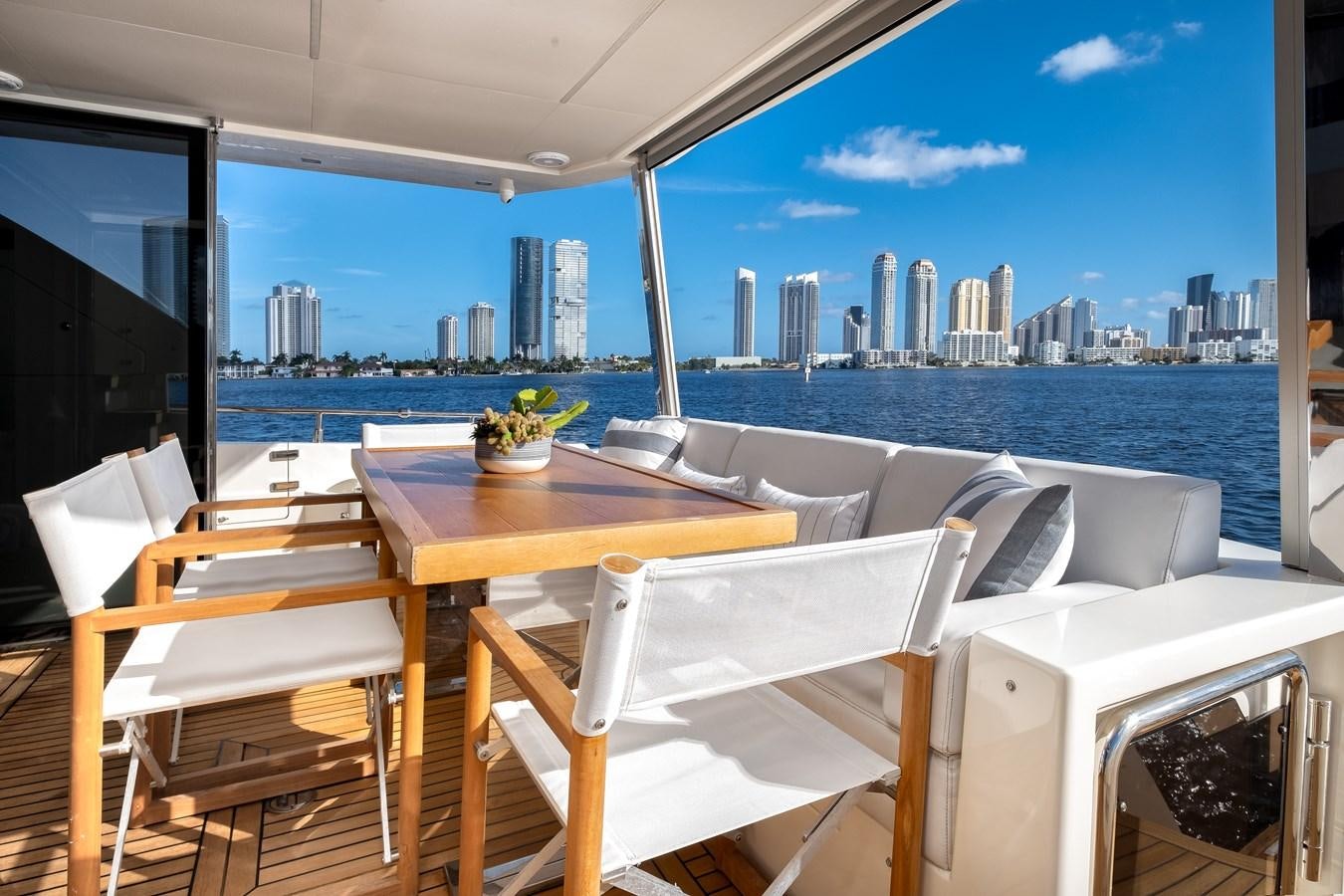 a table and chairs on a deck overlooking a city aboard SHEVA Yacht for Sale