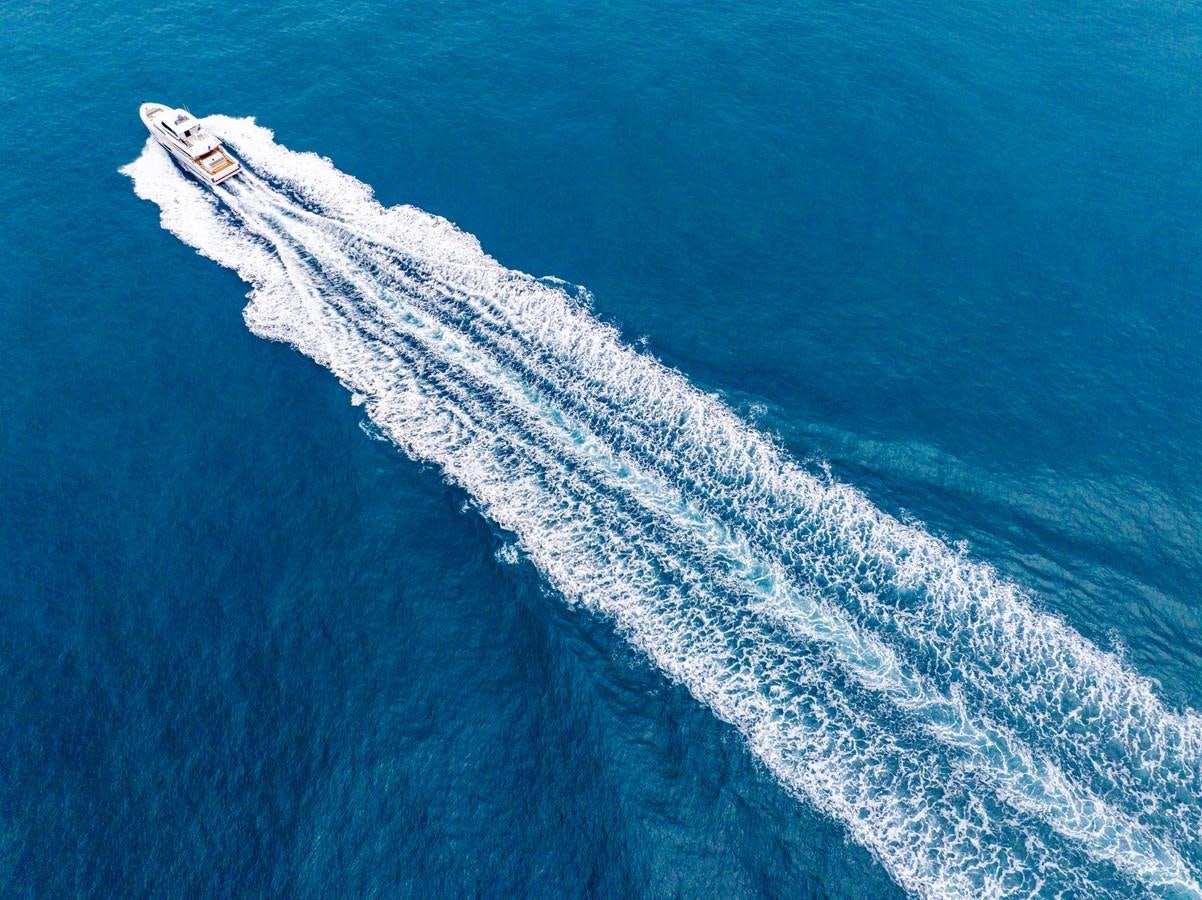 a plane flying over the ocean aboard HORIZON V77 CMY / AVAILABLE NOW Yacht for Sale