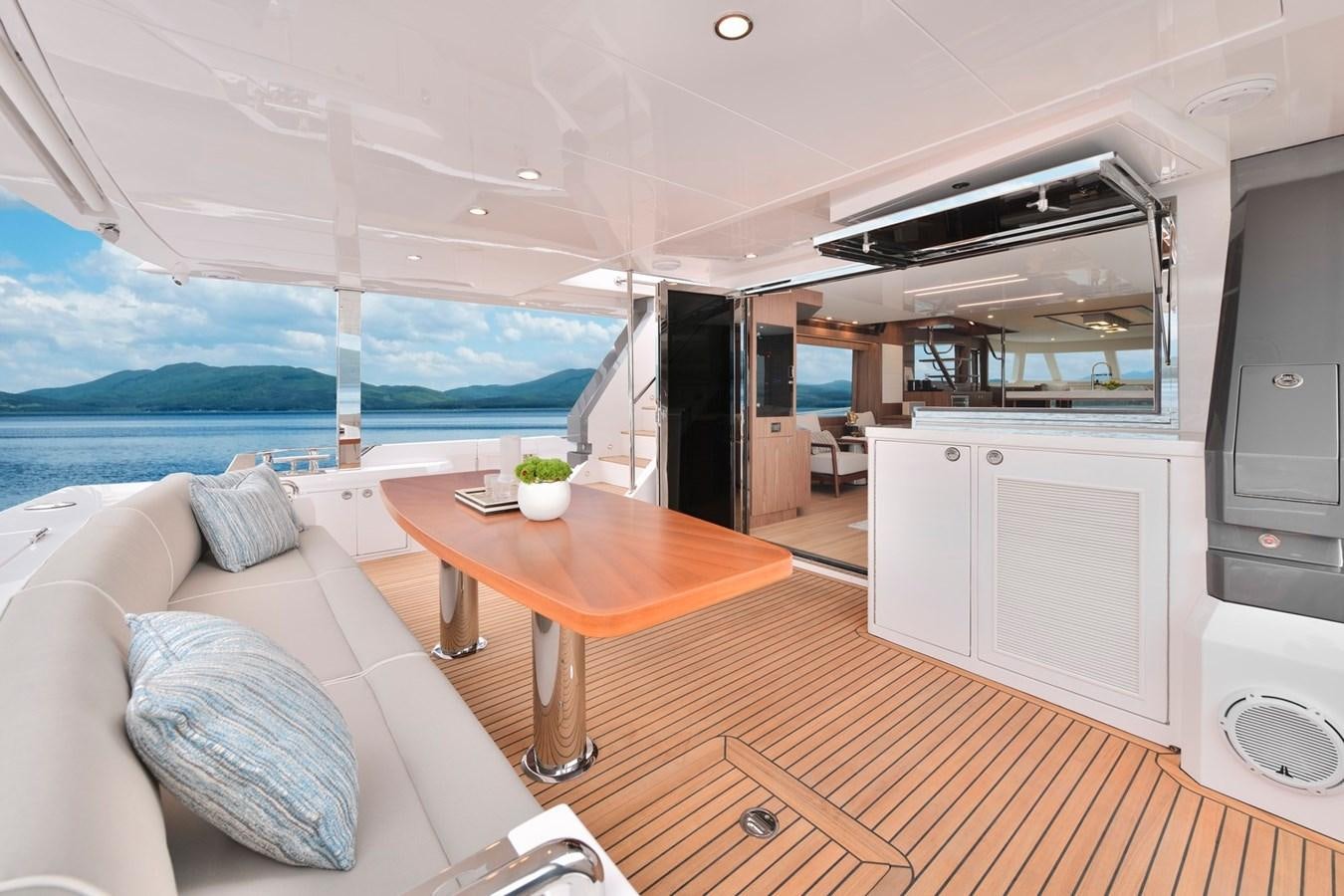 a living room with a table and couches aboard HORIZON V77 CMY / AVAILABLE NOW Yacht for Sale