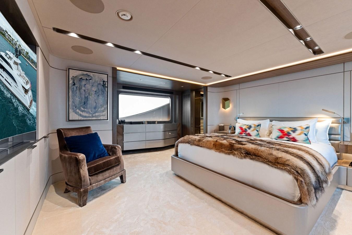 a bedroom with a large bed and a chair aboard SERENITY Yacht for Sale