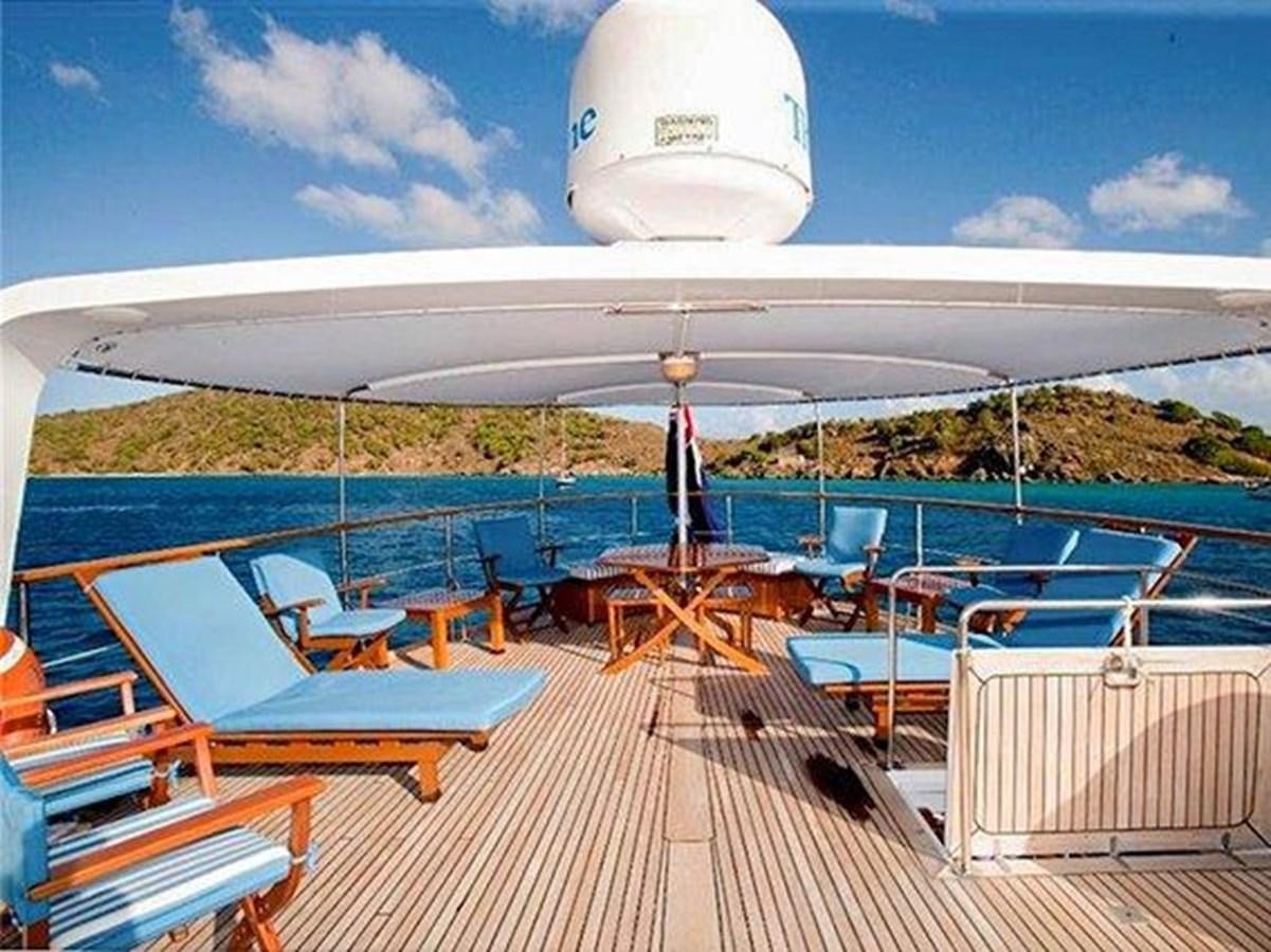 a deck with chairs and a large white airplane in the background aboard LADY ECOSSE Yacht for Sale