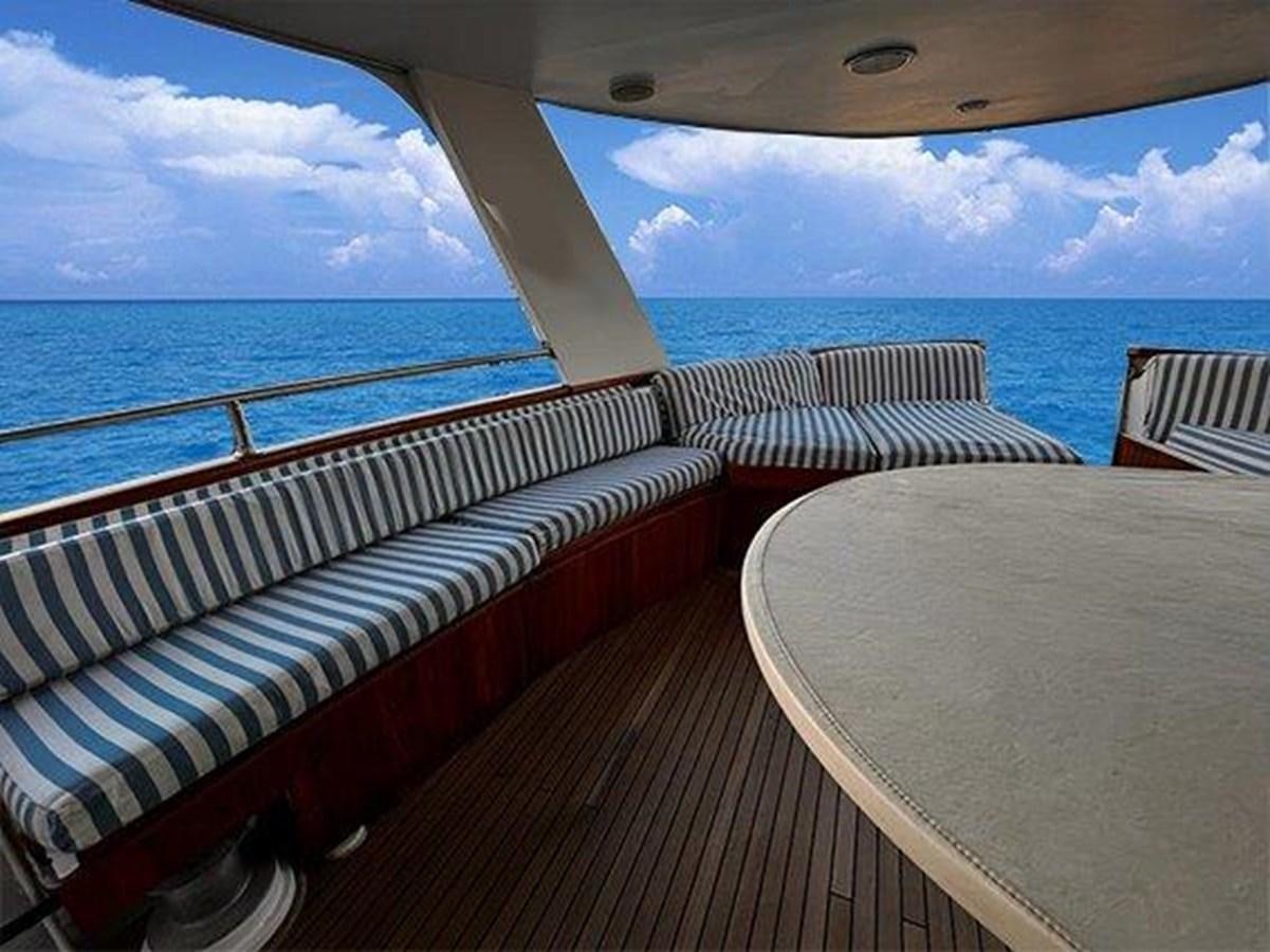 a deck with a table and chairs on it by the ocean aboard LADY ECOSSE Yacht for Sale