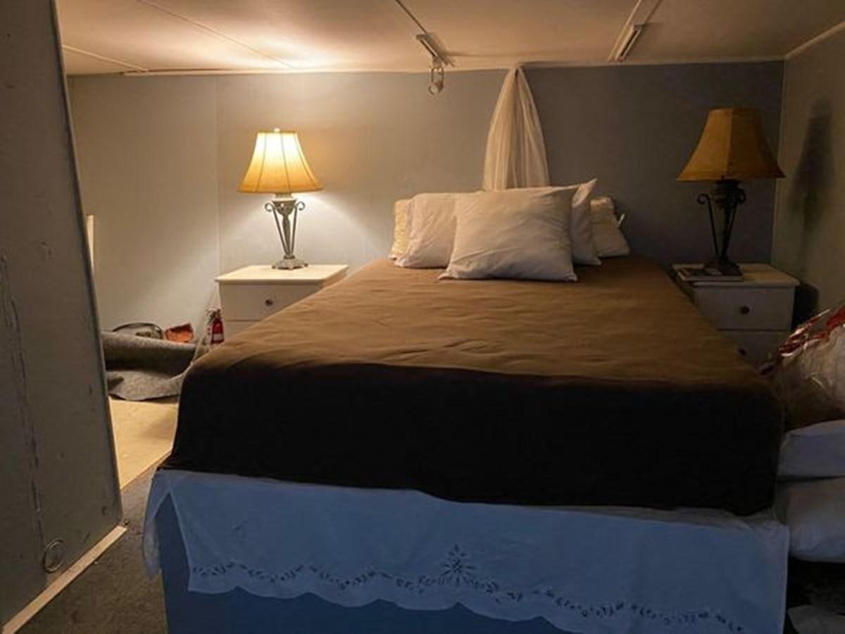 a bed with a black comforter aboard 1986 CUSTOM SEA TREK PASSENGER VESSEL Yacht for Sale